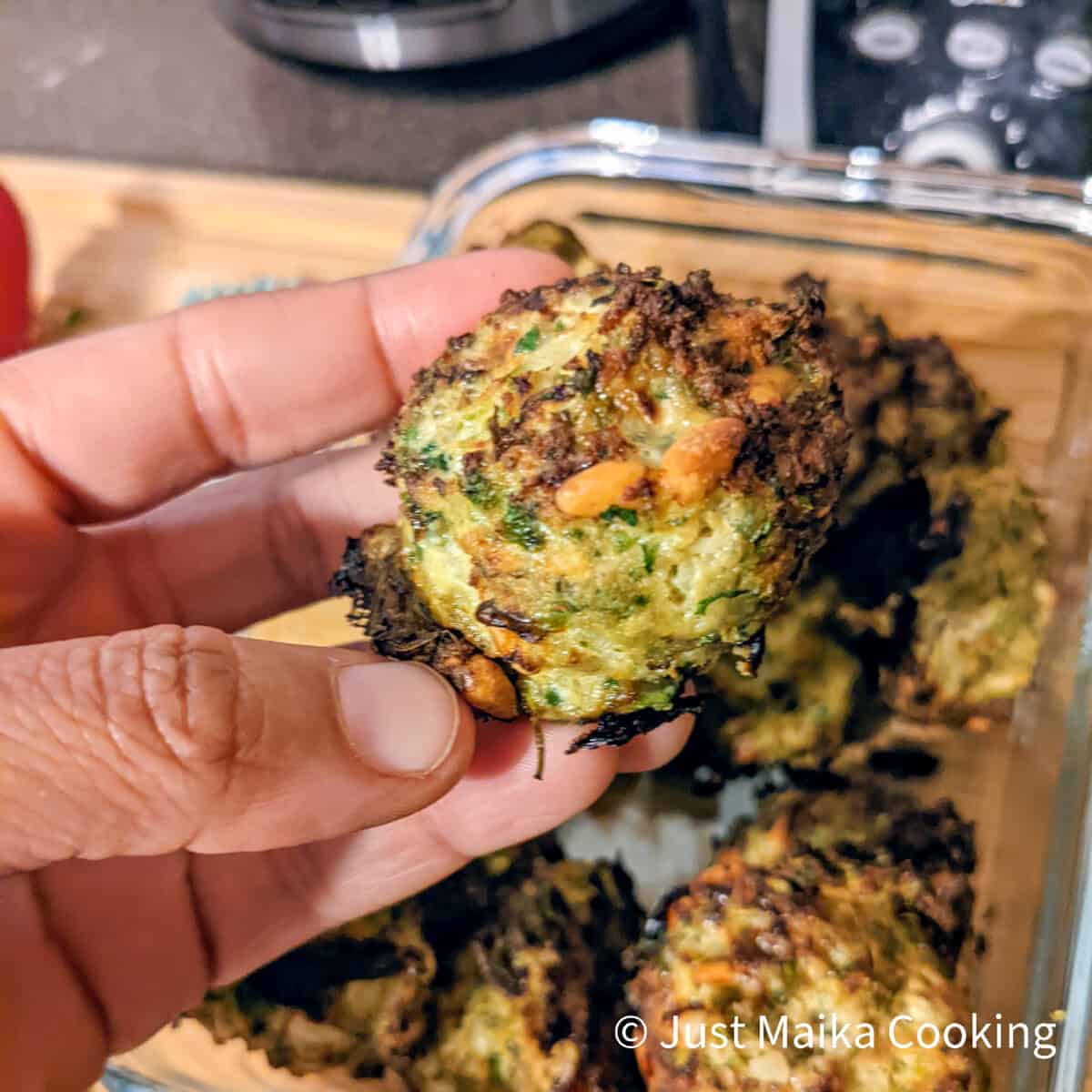 author's hand holding up a cooked turkey meatball